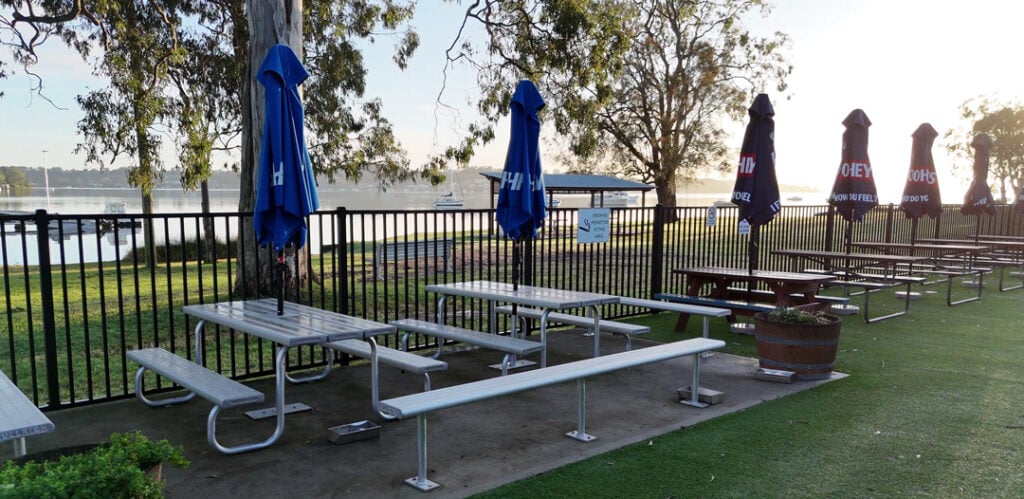 Outdoor tables with umbrellas overlooking the lake at Wangi RSL Club