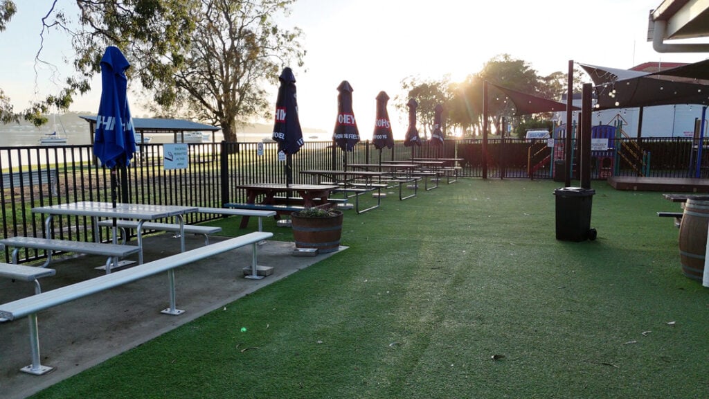 An outdoor seating, play area and overlooking a waterfront.