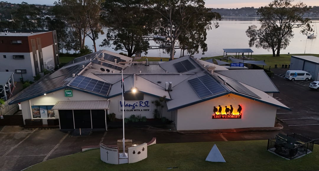 Aerial view of the Wangi RSL club building and its grounds near the water, taken at dusk or dawn.
