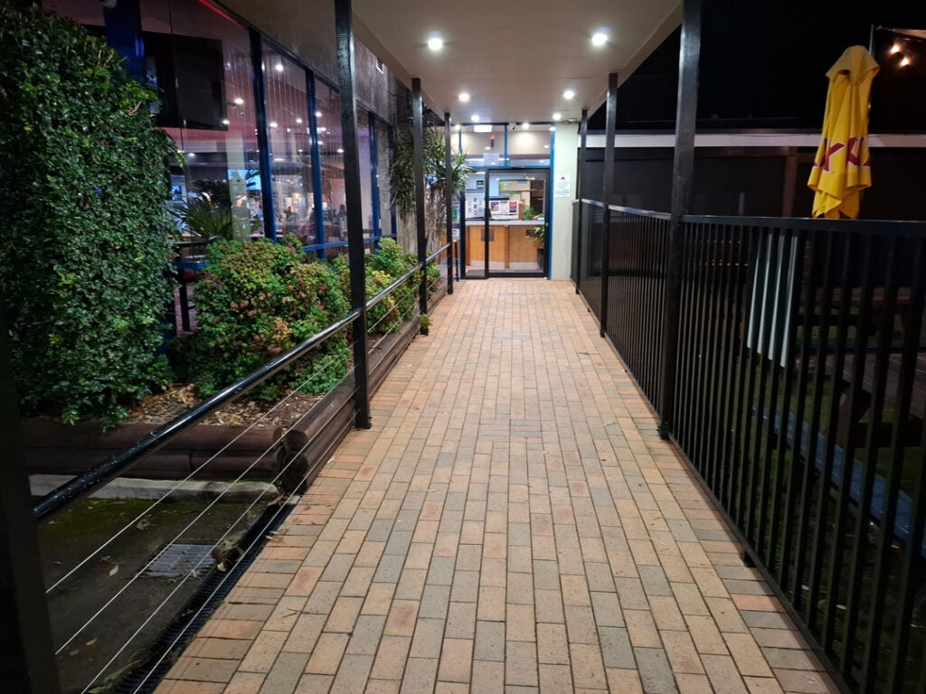 Brick walkway at night leading to Wangi RSL restaurant entrance with plants and railing