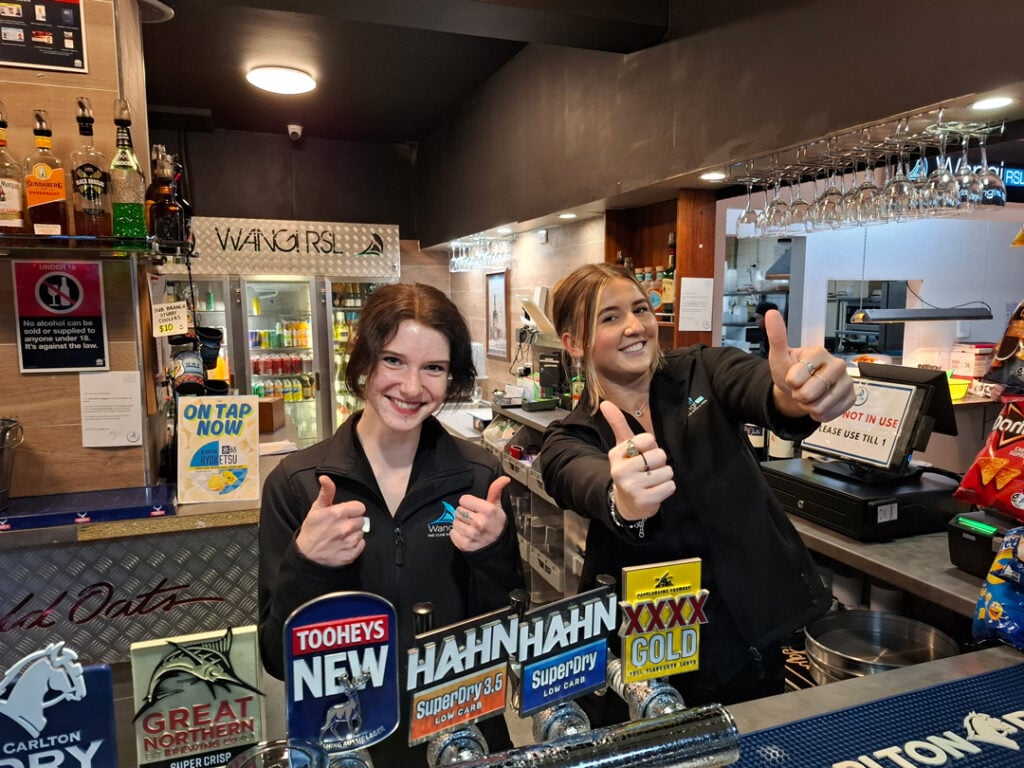 Wangi RSL bar staff smiling and giving thumbs up behind the counter